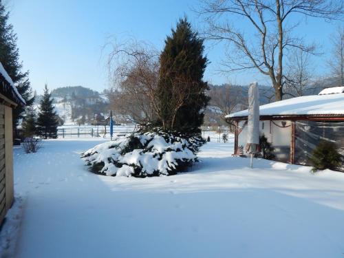 a yard covered in snow next to a house at O.W. Blue Cafe in Krościenko