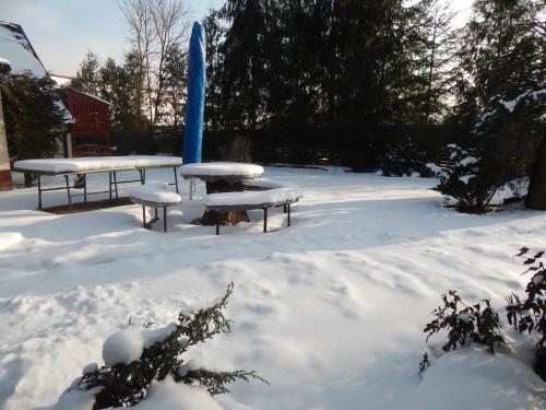 two picnic tables covered in snow in a yard at O.W. Blue Cafe in Krościenko