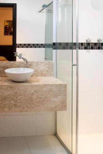 a bathroom with a sink and a glass shower at Bras Palace Hotel in São Paulo