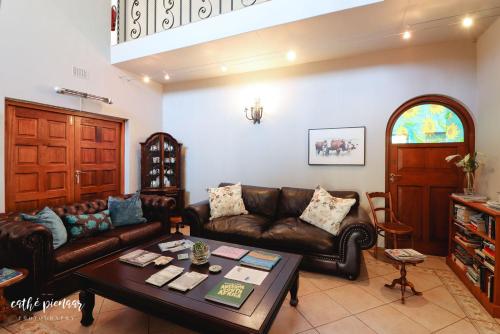 a living room with a couch and a table at A Tuscan Villa Guest House in Fish hoek