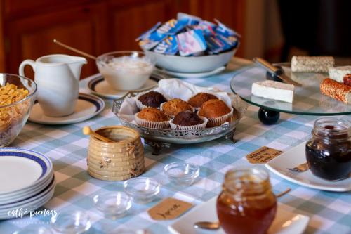 a table topped with plates and bowls of food at A Tuscan Villa Guest House in Fish hoek
