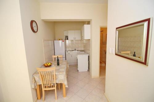 a kitchen and dining room with a table and chairs at Apartments Villa Steffi in Prizba