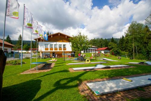 a park with a building with flags in the grass at Knaus Campingpark Lackenhäuser in Neureichenau