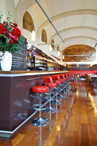 a row of red stools at a bar in a restaurant at Hotel Regina in Vienna