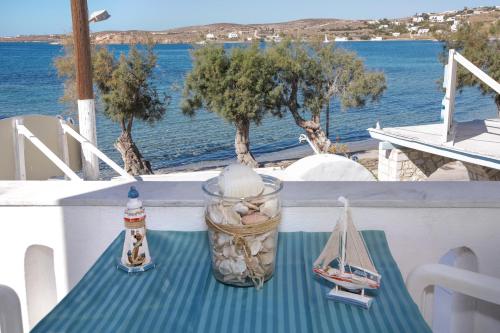 a table with a model boat on a balcony with the water at Alexandra's Rooms in Parikia