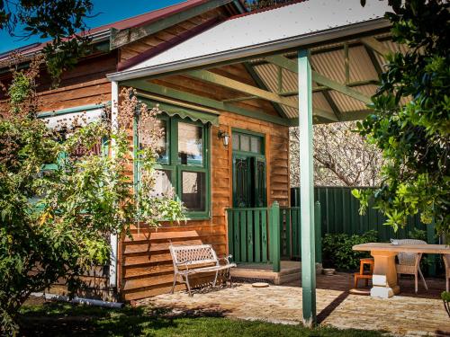 a wooden house with a bench and a table at Peppercorns B&B in McLaren Vale