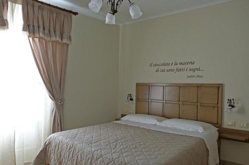 a bedroom with a bed with a sign on the wall at ChocoHouse in Ragusa