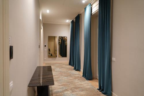 a hallway with blue curtains and a wooden bench at Bergamo Inn 43 in Bergamo