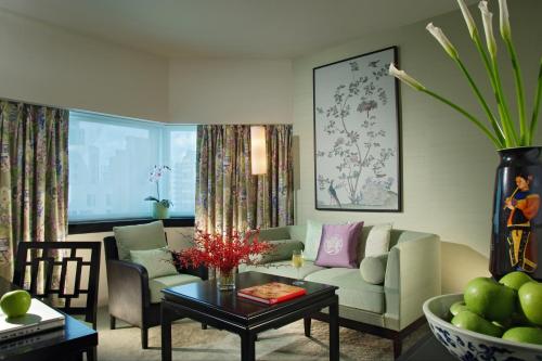 a living room with a couch and a table at Orchard Hotel Singapore in Singapore