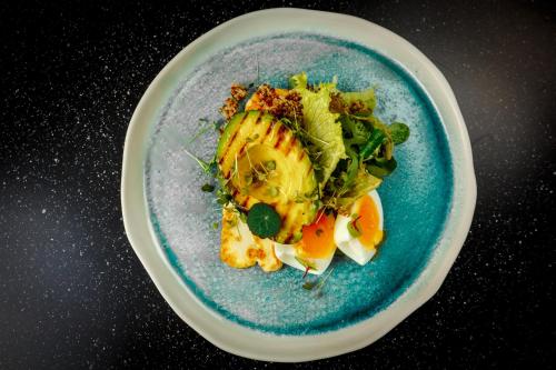 a plate of food with vegetables and fruit on a table at Jurmala Golf Club&Hotel in Piņķi