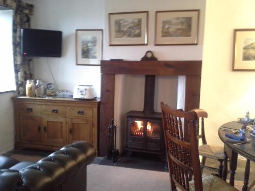 a living room with a fireplace and a couch at Holmeshead Farm in Ambleside