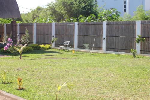 a yard with a wooden fence and a bench at Villa Kayana in Flic-en-Flac