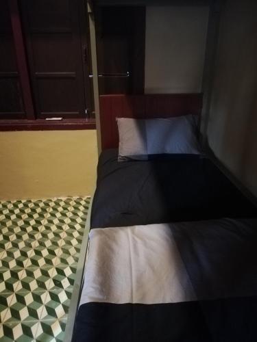 a bedroom with a bed with a checkered floor at Bike&Bed in Thakhek