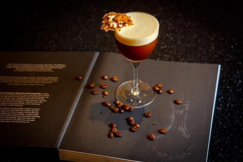 a glass of beer sitting on a book with coffee beans at Jurmala Golf Club&Hotel in Piņķi
