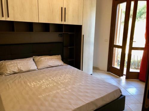 łóżko w sypialni z dużym oknem w obiekcie Calypso Home Sea View w mieście Badesi