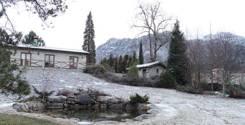 a house on a hill with a pond in front of it at Casa Natura Gerês in Campo do Gerês
