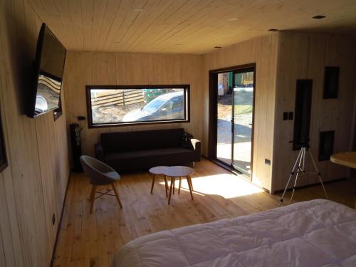 een kamer met een bed, een bank en een raam bij Punta Sal Pichilemu in Pichilemu