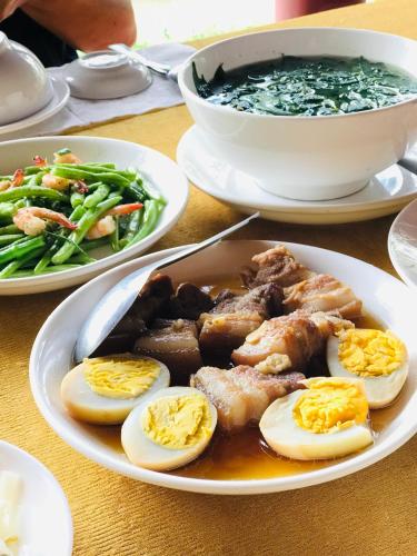 a plate of food with eggs and meat on a table at Ba Danh Homestay & Kitchen - Ben Tre Mekong in Ben Tre