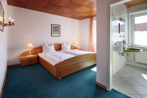 1 Schlafzimmer mit einem großen Bett und einem Badezimmer in der Unterkunft Hotel-Restaurant Sälzerhof in Salzkotten
