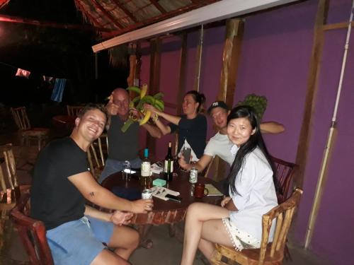 a group of people sitting at a table in a restaurant at Hospedaje Bananas in Altagracia