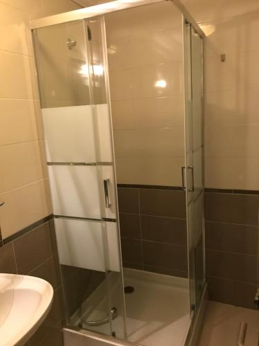 a glass shower in a bathroom with a sink at NN Guest House in Coimbra