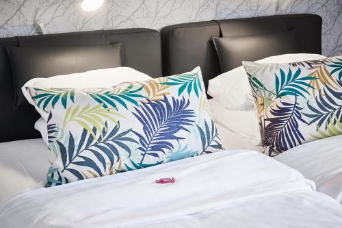 Una cama con almohadas azules y blancas. en Hotell Västerås, en Västerås