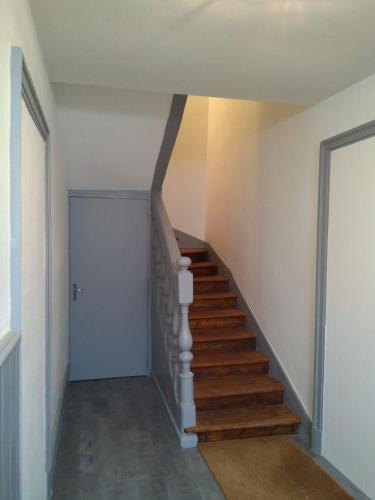 a hallway with a stairway with a blue door at Le studio de Line in Rochefort