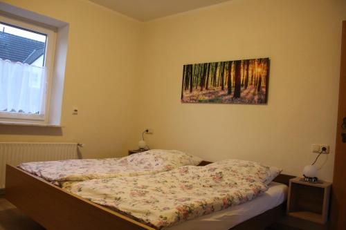 a bed in a bedroom with a painting on the wall at Gollnow in Soltau