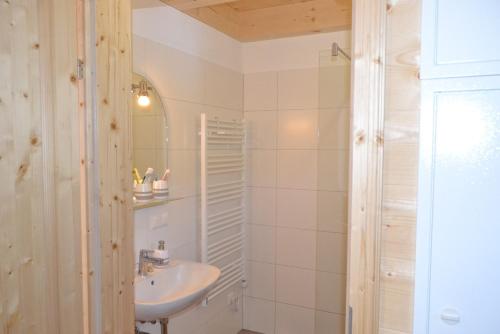Baño blanco con lavabo y espejo en Talhütte App.2, en Hinteralm