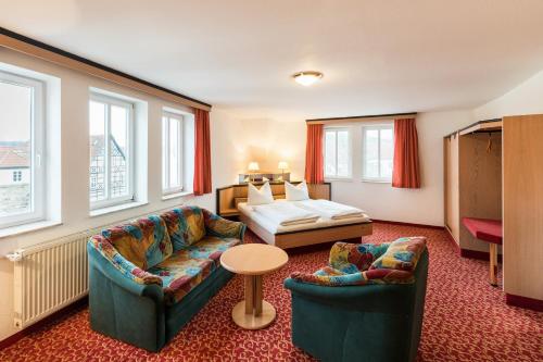 a hotel room with two chairs and a bed at Hotel am Markt in Eisenach