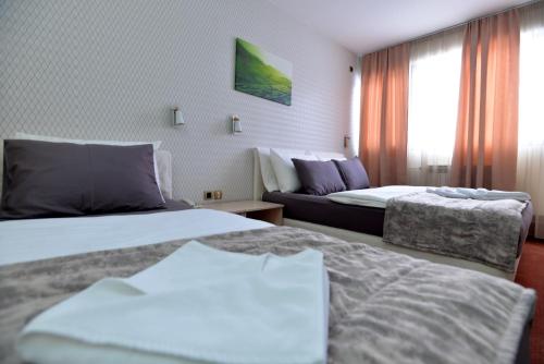 a hotel room with two beds and a window at Hotel Livade in Čačak