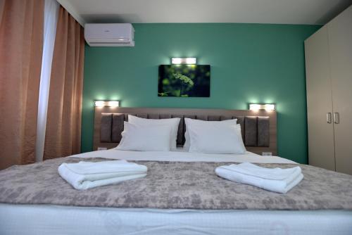 a bedroom with a bed with two towels on it at Hotel Livade in Čačak