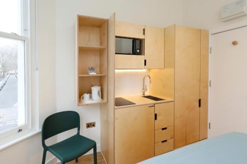 a kitchen with a microwave and a refrigerator at Exhibition Court Hotel in London