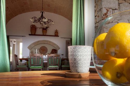 a table with a glass bowl of lemons on it at Le Gioie - Villa Macchia Mediterranea - Splendida villa vista mare immersa nel verde in Torre Pali 