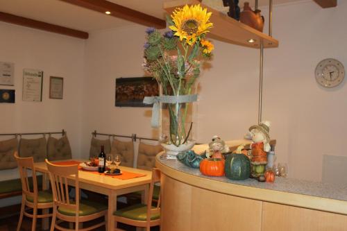 a kitchen with a table and a vase of flowers on a counter at Pension Peterhof in Mörbisch am See