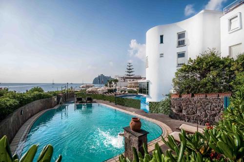 a swimming pool in front of a building at Punta Molino Beach Resort & Thermal Spa in Ischia