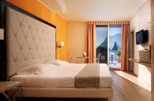 sypialnia z dużym łóżkiem i balkonem w obiekcie Hotel Kristal Palace - Tonelli Hotels - Adult Friendly w mieście Riva del Garda