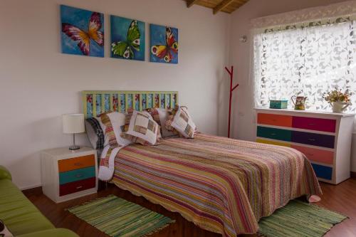 1 dormitorio con 1 cama con colcha colorida en Finca el Refugio del Mundo, en Tabio