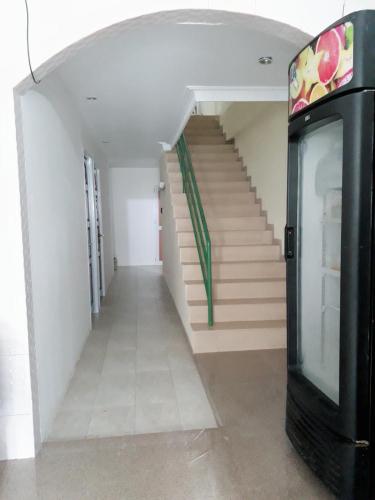 a hallway with stairs and a television in a building at Jakson Homestay in Batam Center