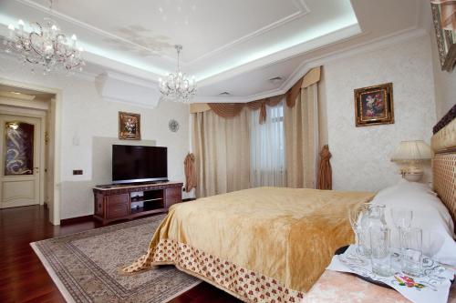 a bedroom with a bed and a flat screen tv at Bortnichi House in Kyiv
