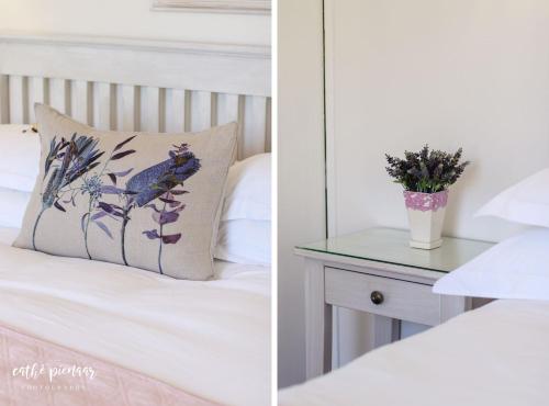 a bedroom with a bed with a pillow and a table at A Tuscan Villa Guest House in Fish hoek