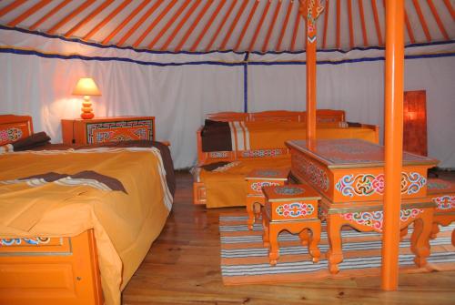 a bedroom with two beds and a tent at yourtes du bocage in Bazoges-en-Pareds
