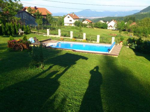 a shadow of a person standing next to a swimming pool at Vila Sani in Sarajevo