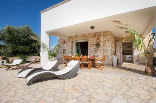 a patio of a house with a table and chairs at Le Gioie - Villa Macchia Mediterranea - Splendida villa vista mare immersa nel verde in Torre Pali 