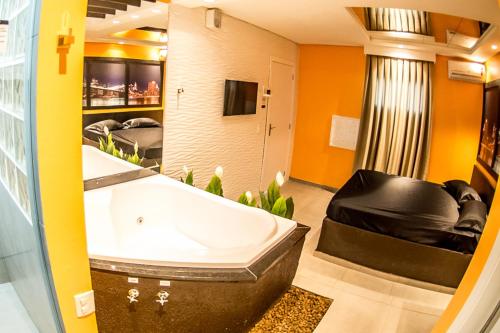 ein großes Bad mit einer Badewanne und einem TV in der Unterkunft Florence Motel Spa in Santa Rosa