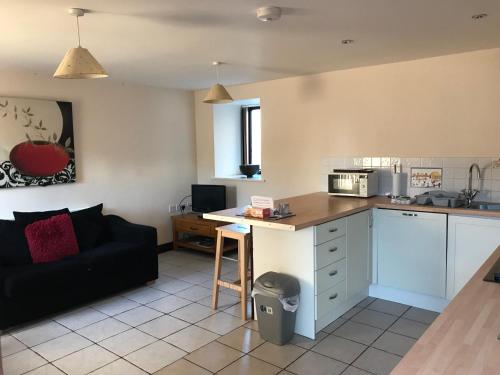 a living room with a couch and a kitchen at Sedbury Farm Cottages in Chepstow
