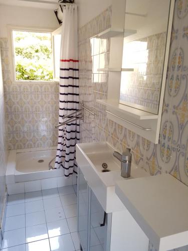 La salle de bains blanche est pourvue d'une baignoire, d'un lavabo et d'une baignoire. dans l'établissement Studio 30 m2 500m Plages MOURILLON 3 Personnes, à Toulon