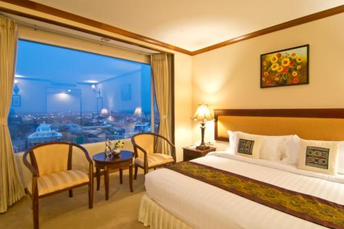 a hotel room with a bed and a large window at Champasak Grand Hotel in Pakse