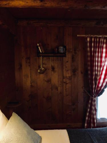 a bedroom with a bed and a window with a curtain at Le Coin Savoyard in Combloux
