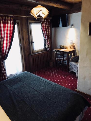 a bedroom with a bed and a table and a window at Le Coin Savoyard in Combloux